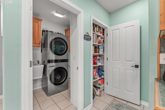 292 Jamie Loop, Roseburg, OR 97471 - laundry area featuring stacked washing machine and dryer, cabinet space, light tile patterned floors, and baseboards