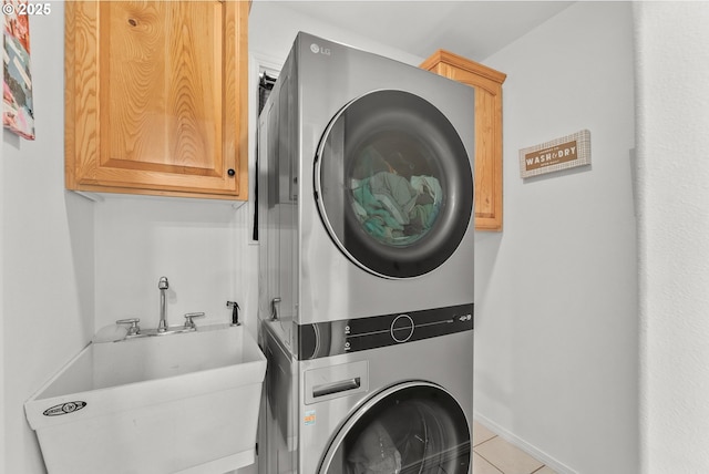 292 Jamie Loop, Roseburg, OR 97471 - laundry area featuring estacked washer and dryer, cabinet space, tile patterned flooring, and baseboards