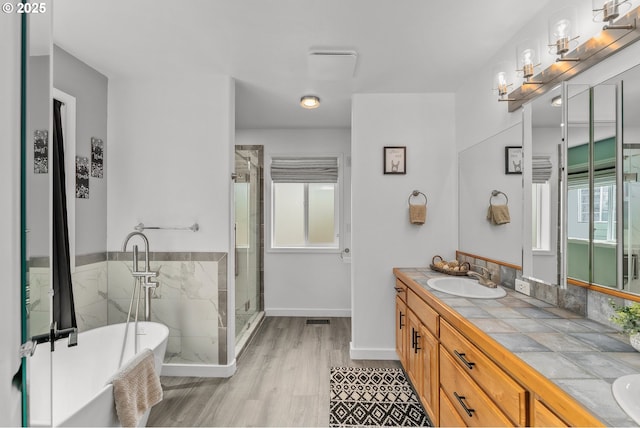 292 Jamie Loop, Roseburg, OR 97471 - bathroom featuring double vanity, a soaking tub, a stall shower, wood finished floors, and baseboards