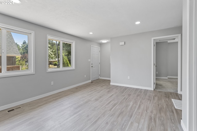 spare room featuring baseboards, recessed lighting, light wood-style flooring, and visible vents