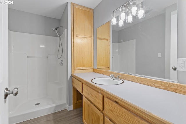 bathroom with vanity, a shower, and wood finished floors
