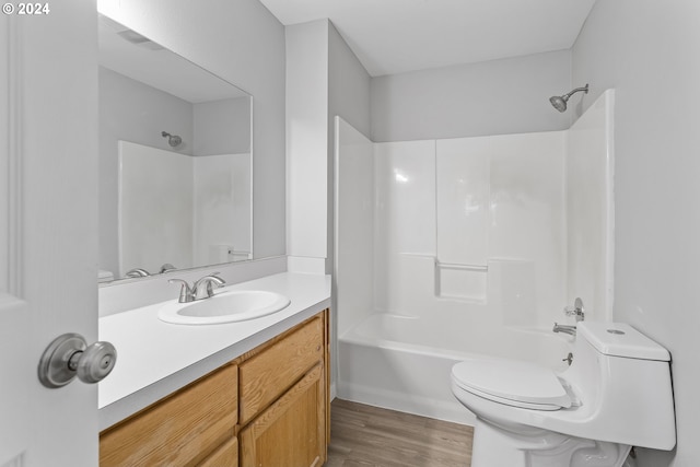 full bathroom with toilet, shower / tub combination, wood finished floors, and vanity