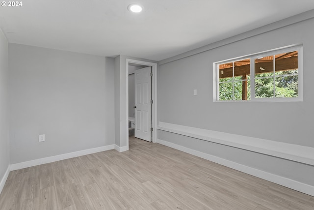 spare room with recessed lighting, baseboards, and light wood-type flooring
