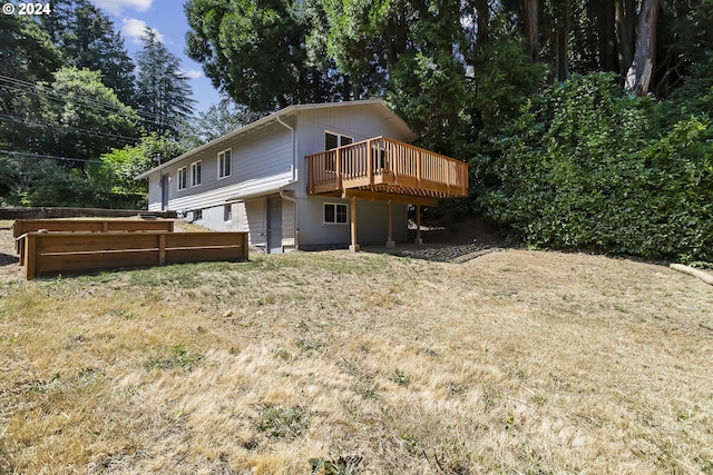 rear view of house featuring a lawn and a deck