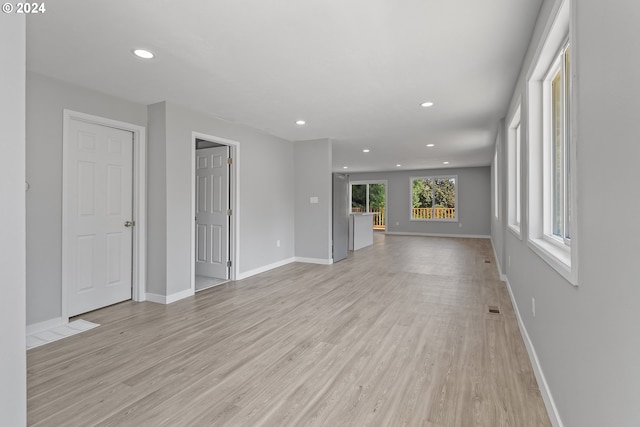 unfurnished living room featuring baseboards, recessed lighting, and light wood-style flooring