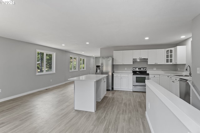kitchen with light wood-style floors, baseboards, light countertops, a sink, and stainless steel appliances