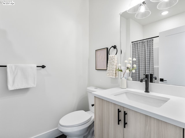 full bath featuring toilet, vanity, and a shower with curtain