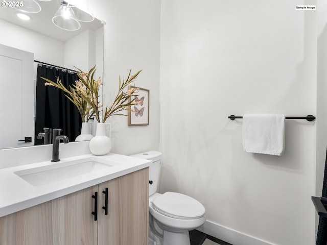 full bath with vanity, toilet, and baseboards