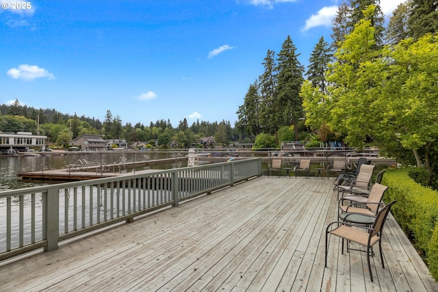 deck featuring view of wooded area and a water view