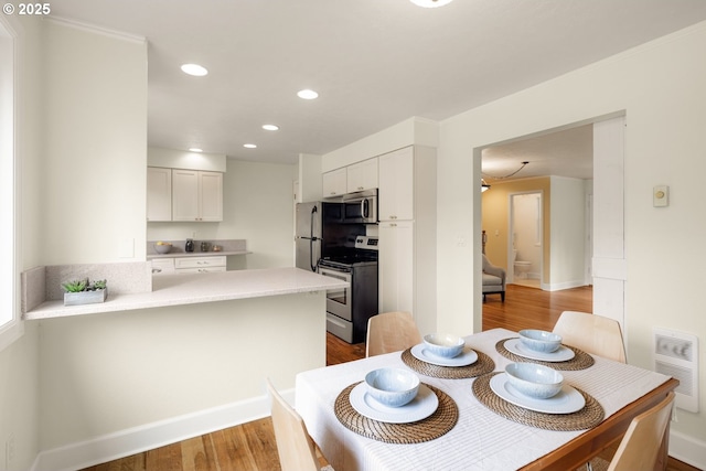 dining space featuring light wood-type flooring, recessed lighting, and baseboards