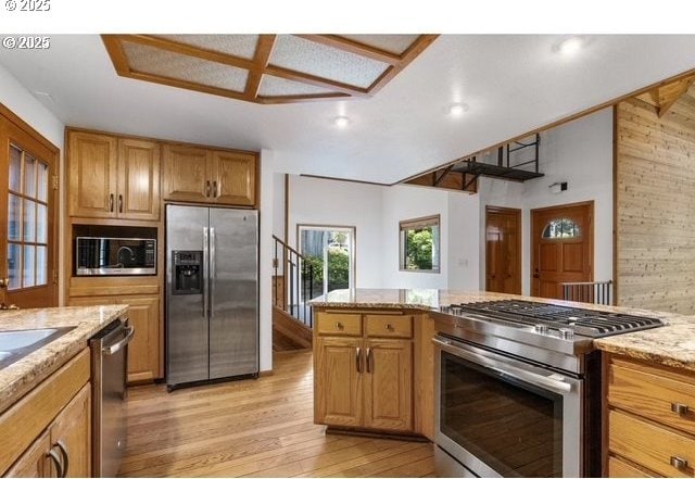 2703 Moon Mountain Dr, Eugene, OR 97403 - kitchen featuring stainless steel appliances, light wood-style floors, light stone countertops, vaulted ceiling, and recessed lighting