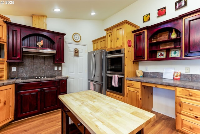 kitchen featuring appliances with stainless steel finishes, wooden counters, built in desk, and light hardwood / wood-style floors