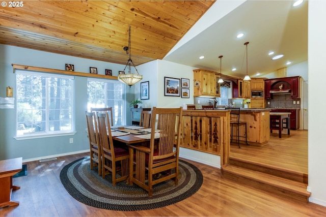 dining area with vaulted ceiling, wood ceiling, and hardwood / wood-style floors