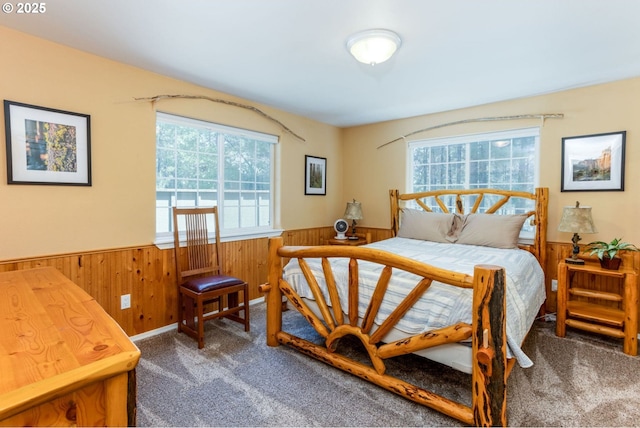 bedroom with carpet floors and wood walls