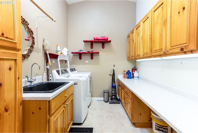 washroom featuring washing machine and dryer, sink, and cabinets