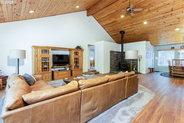 living room with hardwood / wood-style floors, beamed ceiling, a wood stove, wooden ceiling, and high vaulted ceiling