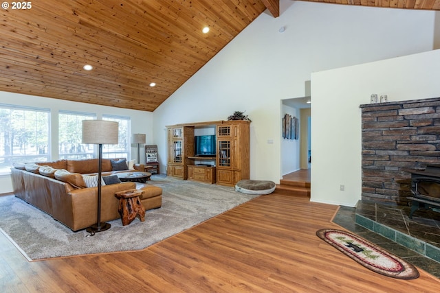 living room featuring hardwood / wood-style flooring, a wood stove, wood ceiling, and beam ceiling