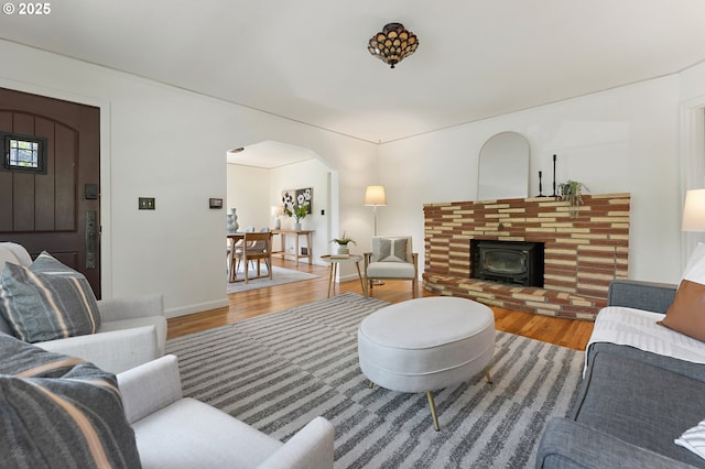 4650 NE Simpson St, Portland, OR 97218 - living room with wood finished floors, arched walkways, and a wood stove