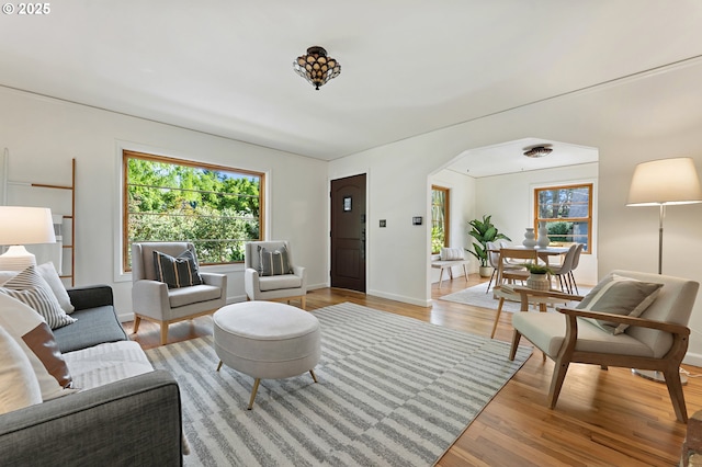 4650 NE Simpson St, Portland, OR 97218 - living area with light wood-style floors, arched walkways, and baseboards