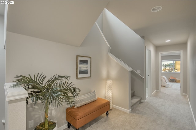 hallway with baseboards, stairway, recessed lighting, and light colored carpet