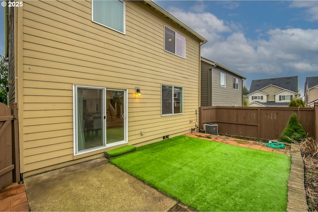 rear view of property featuring central AC, a lawn, and fence