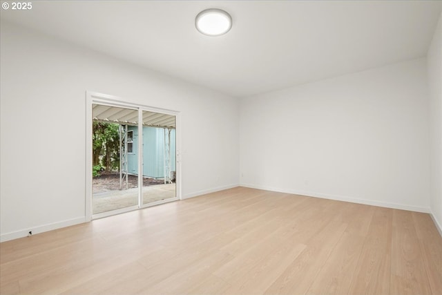 unfurnished room featuring light wood finished floors and baseboards