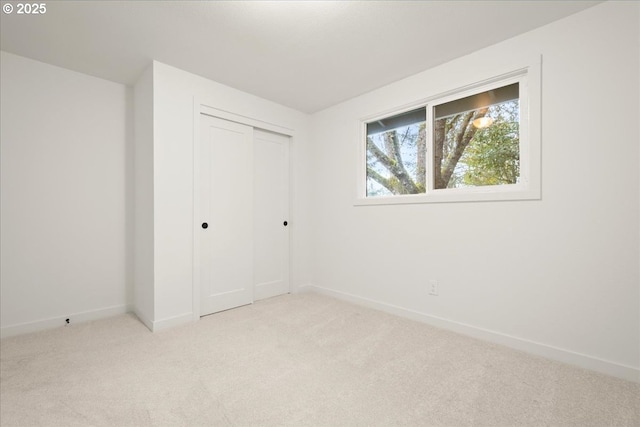 unfurnished bedroom with a closet, carpet, and baseboards