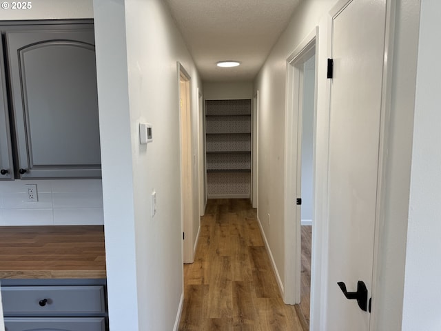 807 Glover St, Goldendale, WA 98620 - corridor with wood finished floors, baseboards, and a textured ceiling