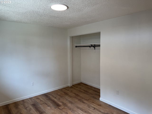 807 Glover St, Goldendale, WA 98620 - unfurnished bedroom with dark wood-style floors, a closet, a textured ceiling, and baseboards