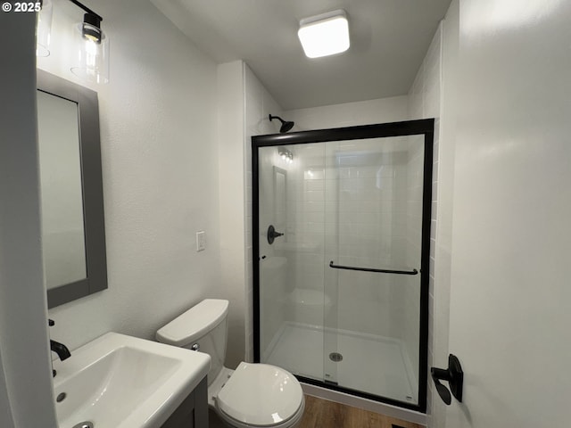 807 Glover St, Goldendale, WA 98620 - bathroom with toilet, a stall shower, a sink, and wood finished floors