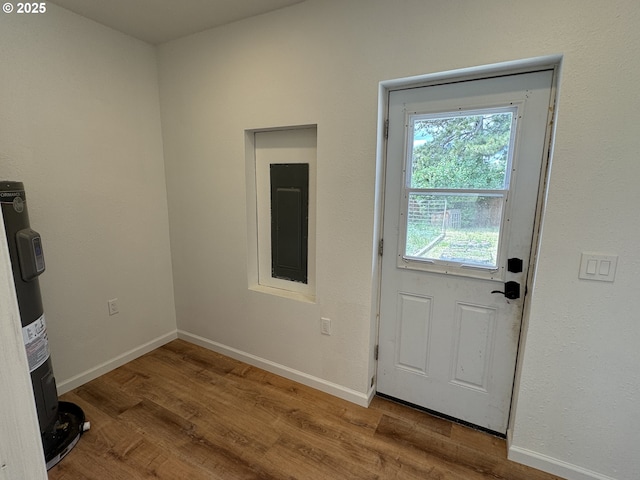 807 Glover St, Goldendale, WA 98620 - doorway with electric panel, electric water heater, wood finished floors, and baseboards