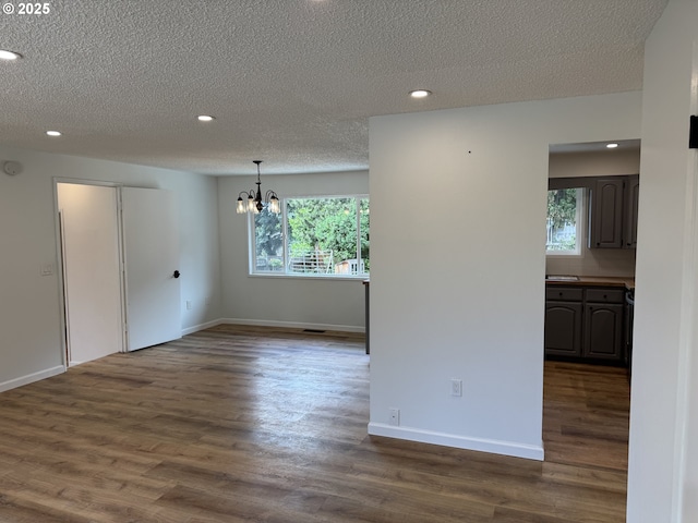 807 Glover St, Goldendale, WA 98620 - spare room featuring a chandelier, recessed lighting, healthy amount of natural light, a textured ceiling, and dark wood finished floors