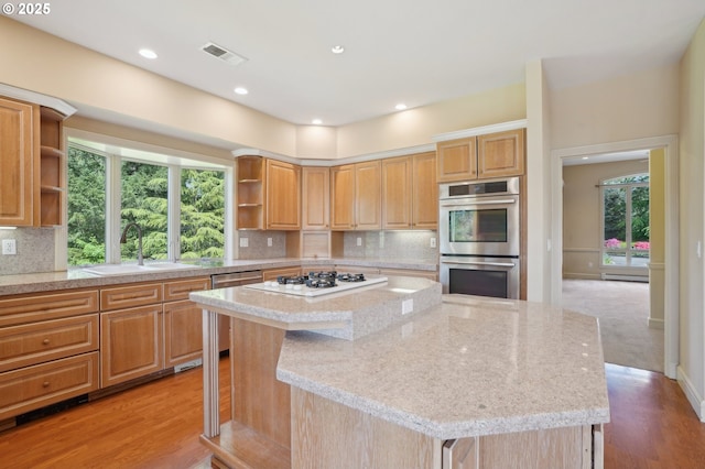kitchen featuring a kitchen island, stainless steel appliances, open shelves, and a sink
