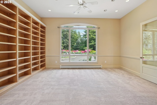 carpeted spare room with baseboards, ceiling fan, a wealth of natural light, and a baseboard radiator