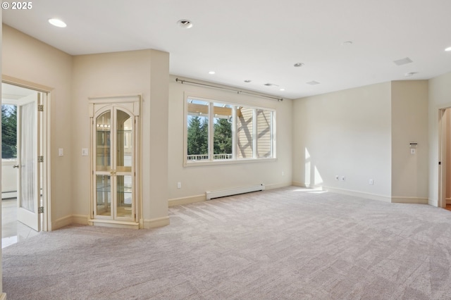 empty room with baseboards, light carpet, and baseboard heating