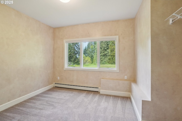 spare room featuring carpet floors, a baseboard radiator, and baseboards