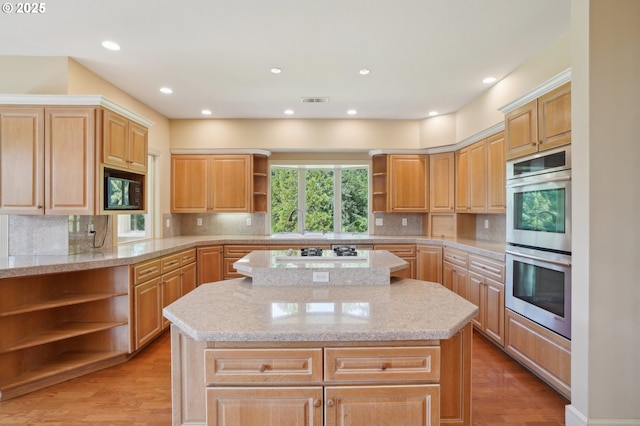 kitchen featuring white gas cooktop, open shelves, stainless steel double oven, light wood-style floors, and a kitchen island