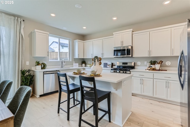 4321 Dogwood Ave SE, Albany, OR 97322 - kitchen featuring stainless steel appliances, light countertops, a kitchen island, and white cabinetry