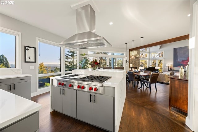 kitchen featuring pendant lighting, gray cabinetry, stainless steel gas cooktop, island exhaust hood, and dark hardwood / wood-style flooring