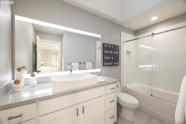 full bathroom with vanity, toilet, and bath / shower combo with glass door