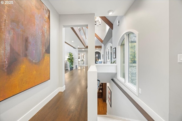 corridor with hardwood / wood-style flooring and vaulted ceiling