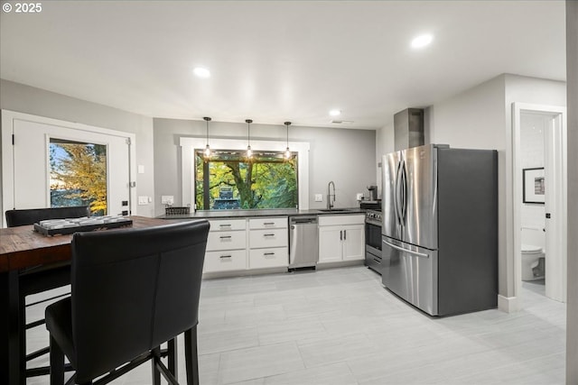 kitchen with pendant lighting, a wealth of natural light, stainless steel appliances, and white cabinets
