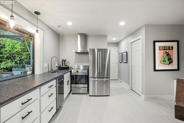 kitchen with pendant lighting, sink, white cabinets, stainless steel appliances, and wall chimney exhaust hood