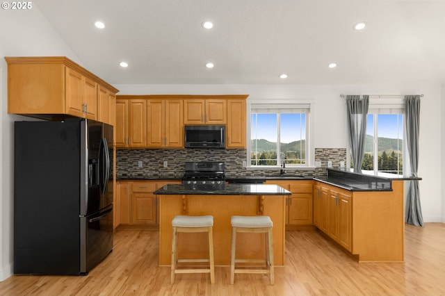 15708 SE Bybee Dr, Portland, OR 97236 - kitchen featuring refrigerator with ice dispenser, black microwave, gas stove, a kitchen island, and tasteful backsplash