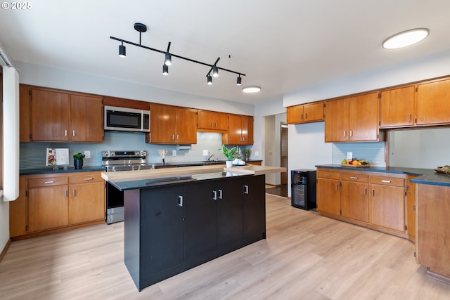 kitchen with dark countertops, brown cabinetry, and stainless steel appliances