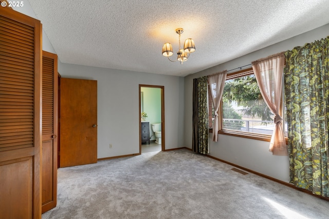 unfurnished bedroom with baseboards, visible vents, light colored carpet, a notable chandelier, and a closet