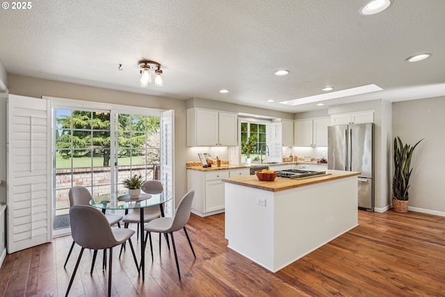 209 Mcnary Estates Dr N, Keizer, OR 97303 - kitchen featuring stainless steel appliances, wood counters, a kitchen island, white cabinetry, and dark wood finished floors