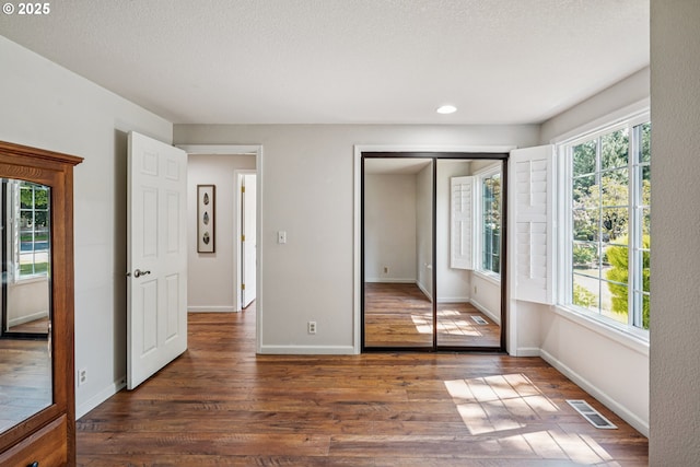 209 Mcnary Estates Dr N, Keizer, OR 97303 - unfurnished bedroom featuring dark wood-type flooring, multiple windows, a closet, and recessed lighting