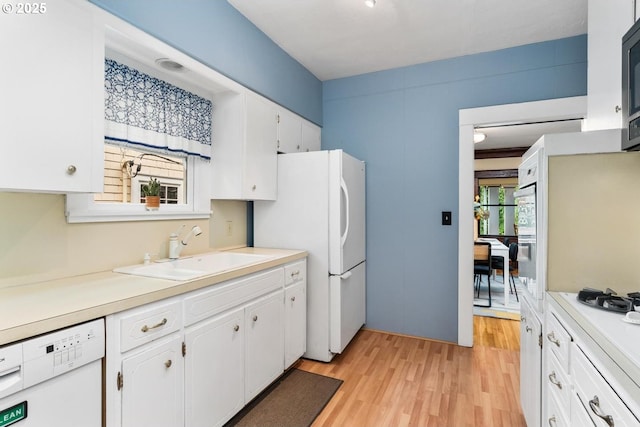 2522 NE 50th Ave, Portland, OR 97213 - kitchen with a sink, white appliances, light wood-style flooring, white cabinets, and light countertops