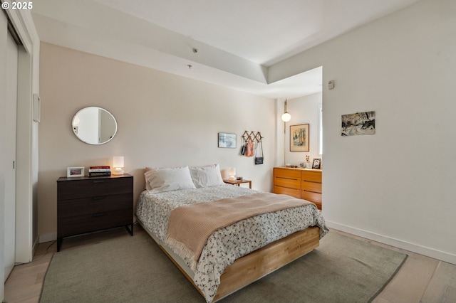 bedroom with light wood-type flooring and baseboards